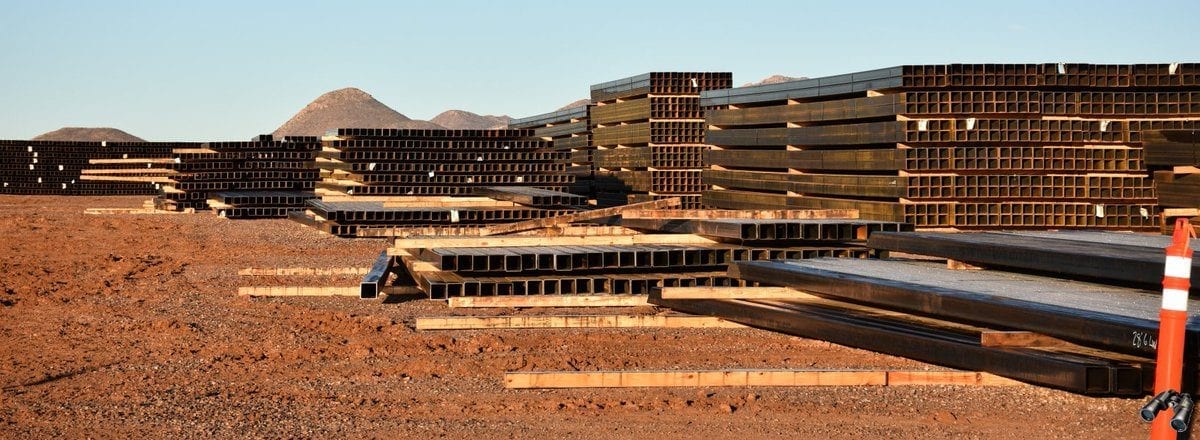 Steel stock stored across a large outdoor laydown yard